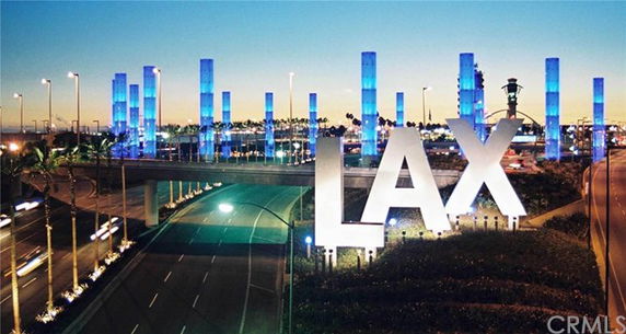 Front view of LAX airport entrance with illuminated pylons.