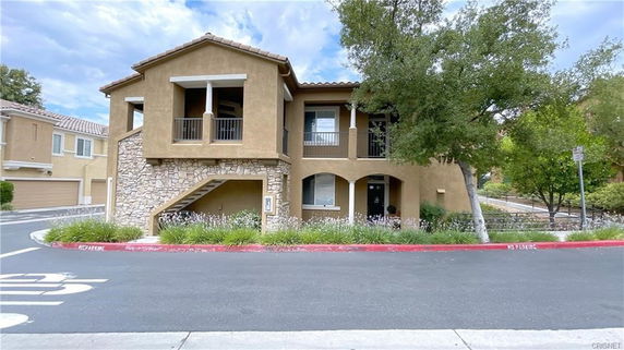 Front view of a two-story house with stone and stucco exterior.