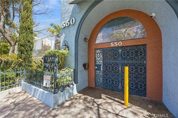 Front view of building entrance with ornate metal gate and arched design.