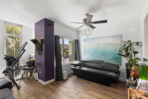 Indoor recreation area with fitness equipment and a tanning bed.