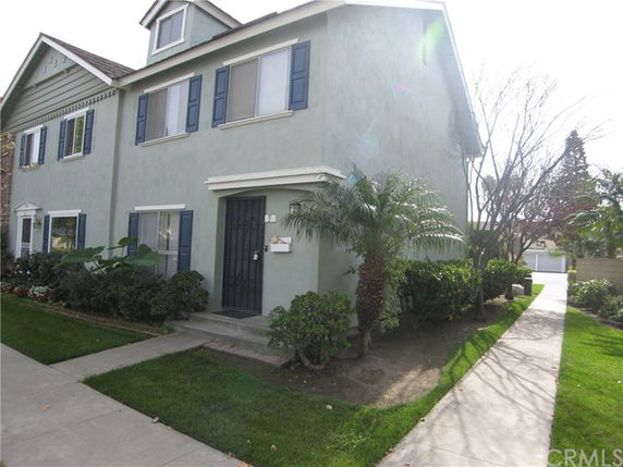Front view of a two-story house with green exterior and blue shutters.