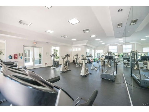 Indoor gym area with exercise equipment and mirrored walls.