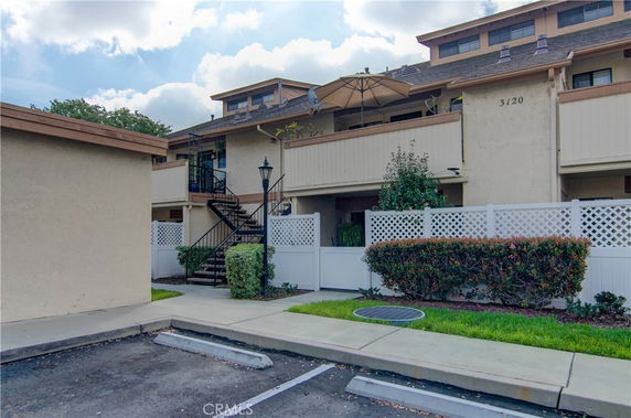 Front view of a multi-level building with an outdoor staircase and balconies.