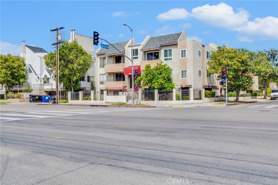 Front view of a multi-story apartment building at a street corner.