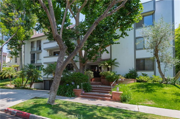 Front view of a multi-story building with trees and greenery.
