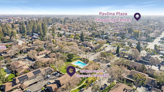 Panoramic view of a neighborhood with a swimming pool and shopping center visible.