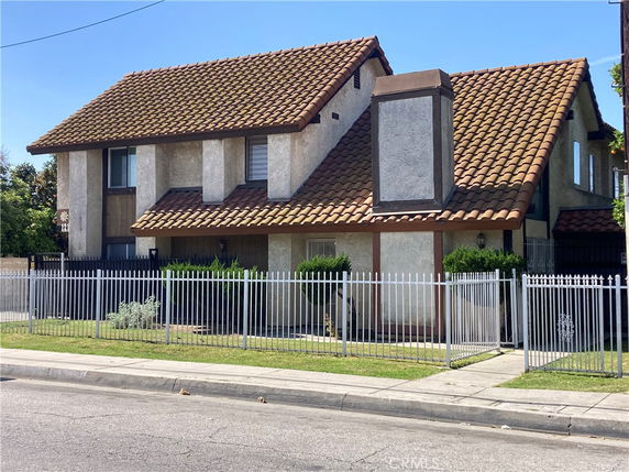 Front view of a two-story house with a tiled roof and chimney.