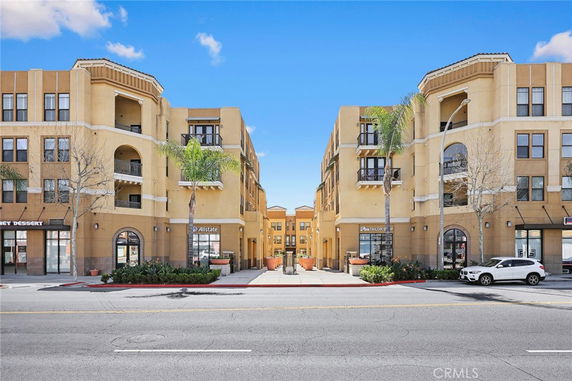 Front view of a multi-story building with retail shops on the ground floor.