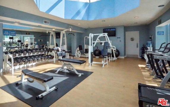 Interior view of a gym with exercise equipment and weights.