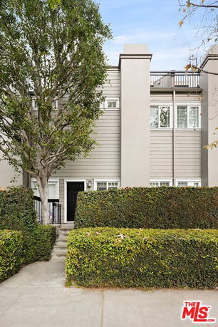 Front view of a multi-story house with a modern design and a small front porch.
