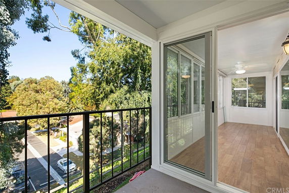 Balcony view overlooking a residential area with trees and houses.