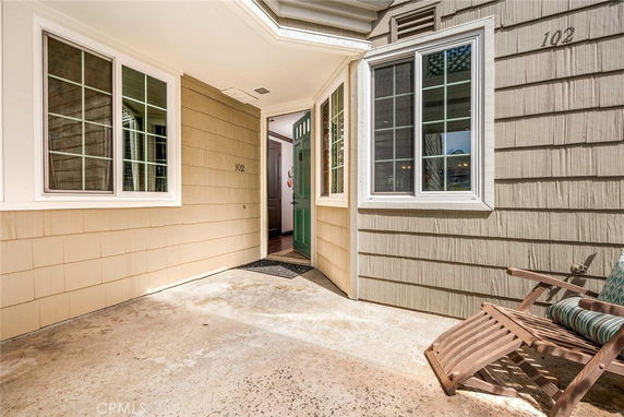 Front view of a house entryway with windows and an open door.
