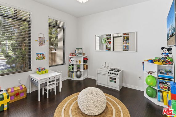 Indoor children's play area with toys, a small table, and a pretend kitchen.