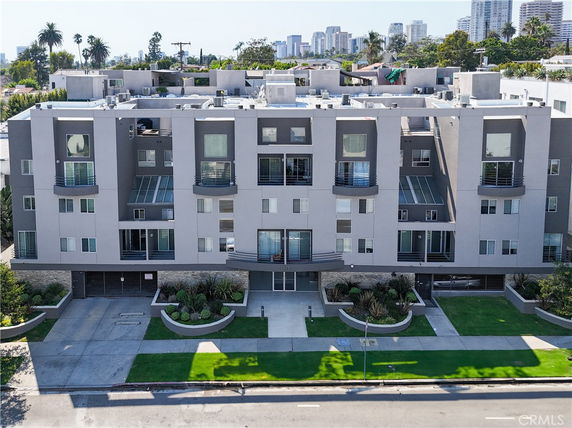 Front view of a multi-story apartment building with balconies.