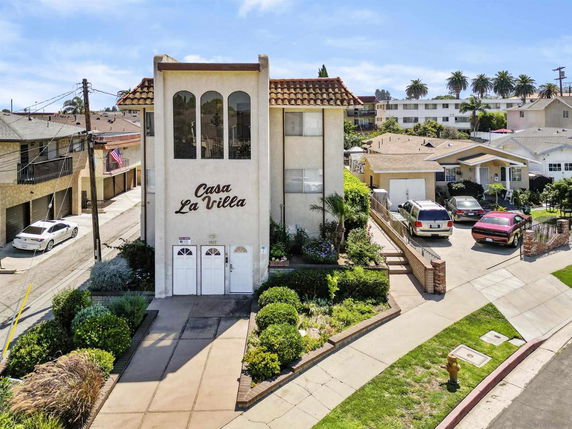 Front view of a three-story building with a tiled roof named Casa La Villa.