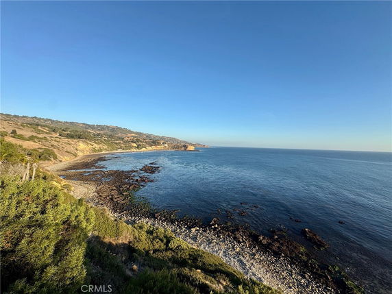 Panoramic view of a coastal area with rocky shoreline and clear blue ocean.