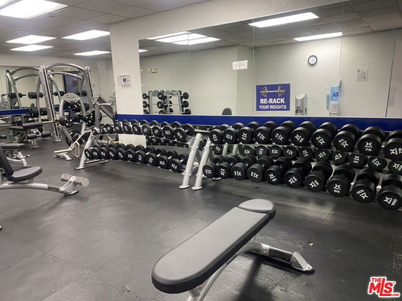Indoor gym area with weights and exercise equipment.