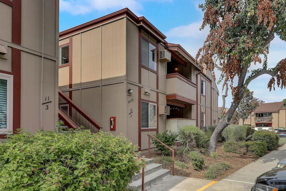 Front view of a two-story residential building with beige and brown accents.