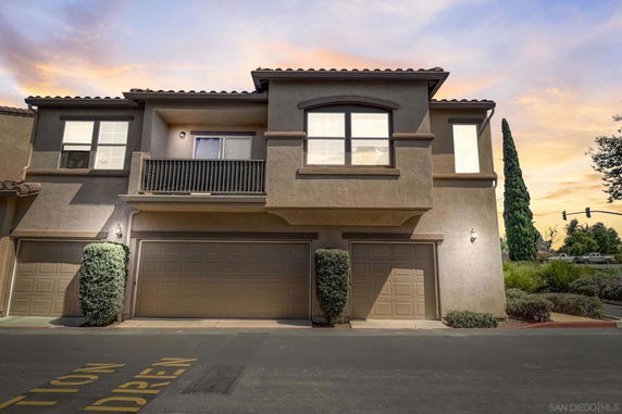 Front view of a two-story house with attached garages and a small balcony.