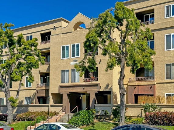 Front view of a multi-story apartment building with a beige facade.