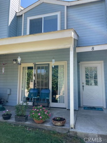 Front view of a two-story house with a small porch and blue siding.