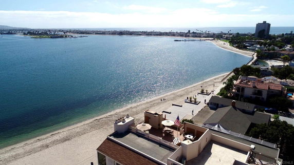 Panoramic view of a coastal area with beachfront houses and a wide stretch of ocean.