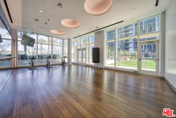 Interior view of a large room with exercise bikes and large windows, suitable for fitness activities.