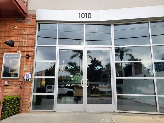 Front view of a building entry with large glass doors and windows.