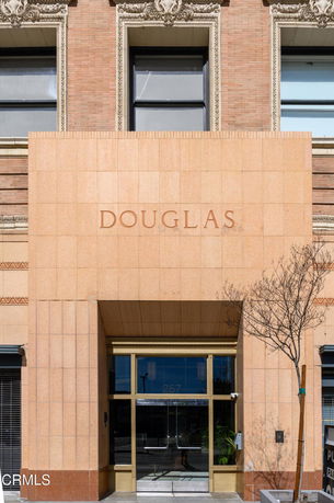 Front view of a building entrance with the name 'Douglas' on the facade.