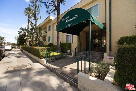 Front view of a two-story building with a green awning entrance.