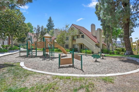 Residential area with outdoor play equipment including slides and climbing structures.