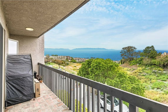 Balcony view overlooking the ocean and surrounding landscape.