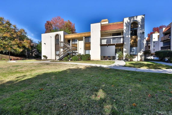 Front view of a two-story apartment building with exterior staircases and balconies.
