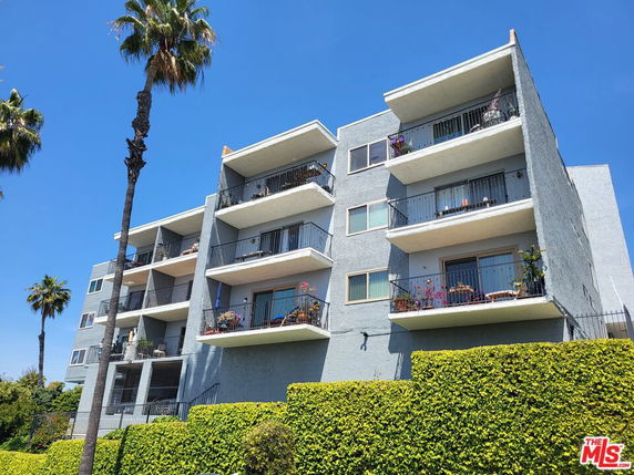 Front view of a multi-story apartment building with balconies.
