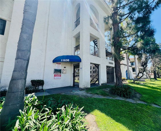 Front view of a multi-story building with a blue canopy over the entrance.