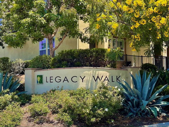 Front view of Legacy Walk building with surrounding plants and trees.