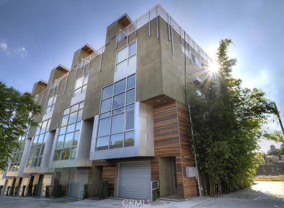 Front view of a modern multi-story building with large windows and a garage entrance.