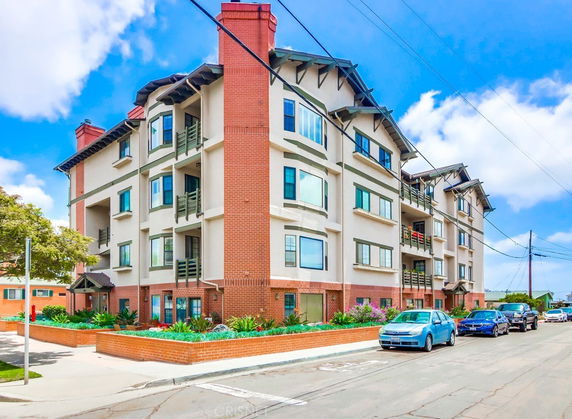 Front view of a multi-story apartment building with brick and stucco exterior.