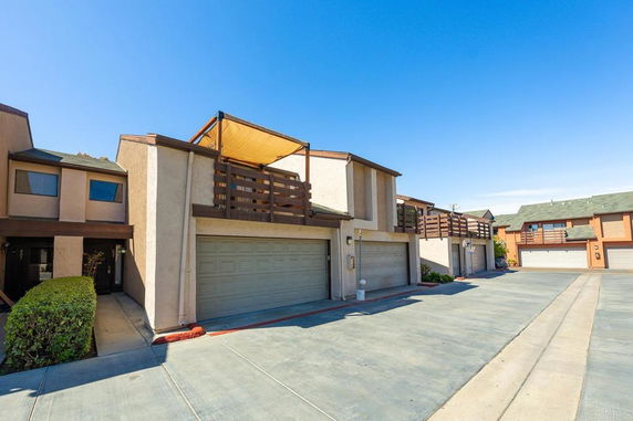 Front view of a townhouse with a double garage and balcony.