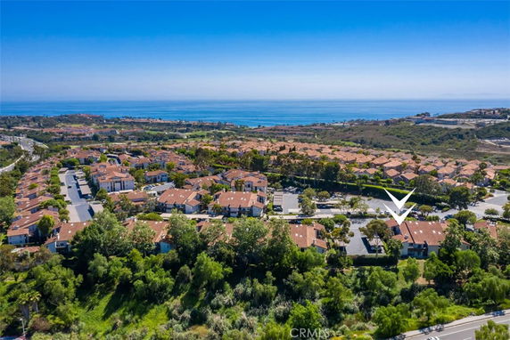 Panoramic view of a residential area with houses and ocean in the background.