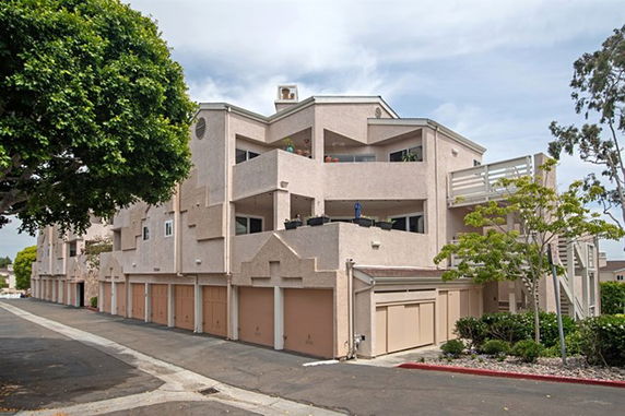 Front view of a multi-story residential building with multiple garages.