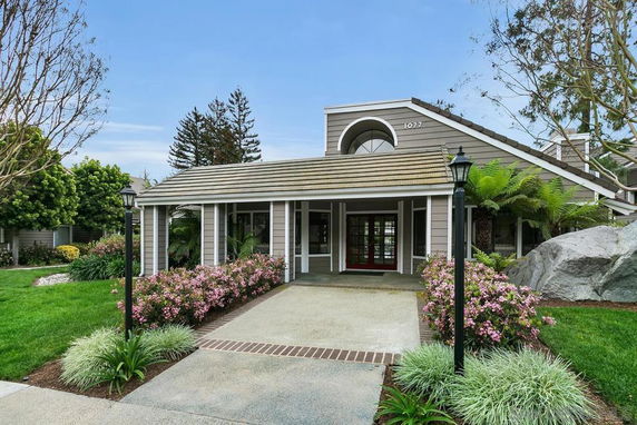 Front view of a single-story house with a covered entrance and sloped roof.