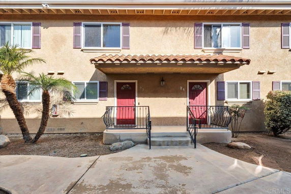 Front view of a two-story building with two entrances and red doors.