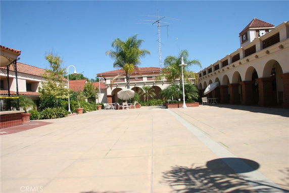 Front view of a building with arched colonnades and red-tiled roofs, surrounding a central courtyard.