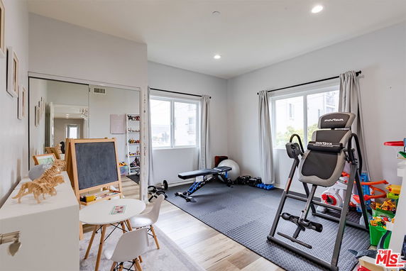 Room with exercise equipment and children's play area.