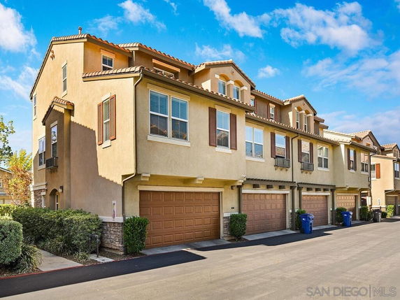 Front view of a multi-story townhouse complex with multiple garages.