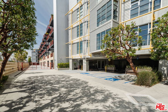 Front view of a multi-story building with large windows and yellow structural accents.