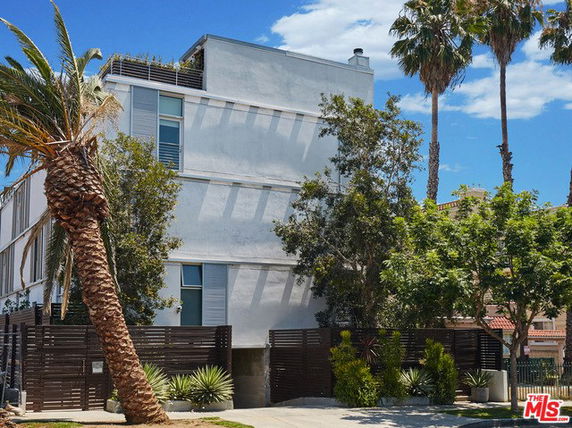 Front view of a multi-story modern building with a flat roof and minimalistic design.