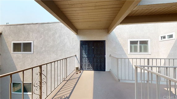 Front view of a building entrance with wrought iron door and railing