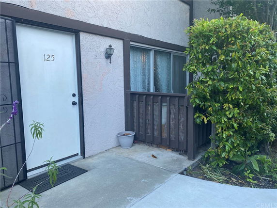 Front view of a house with a white door and a window beside it.